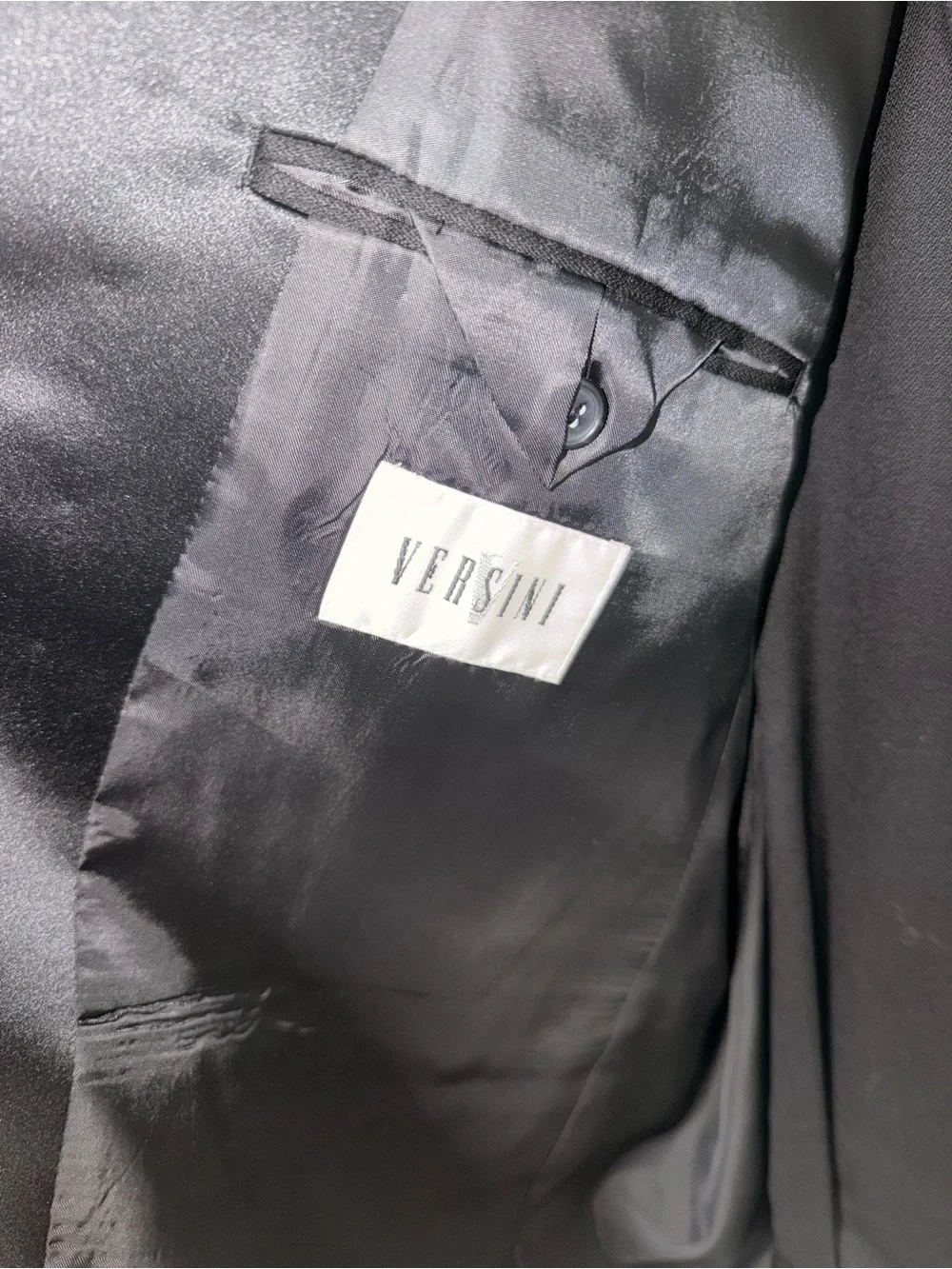 black Versini tuxedo jacket with a single-button closure and satin notch lapels.